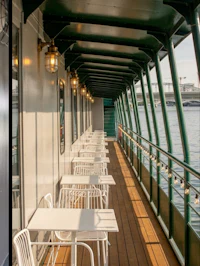 the deck of a boat with tables and chairs