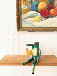 a frog sitting on a wooden shelf